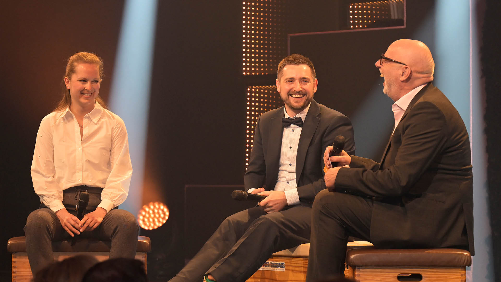 Andreas Kuhnt lacht herzlich beim Gala-Interview mit Marco Herbst. Von links: Hannah Strobel von Lotto Niedersachsen, Marco Herbst, Andreas Kuhnt