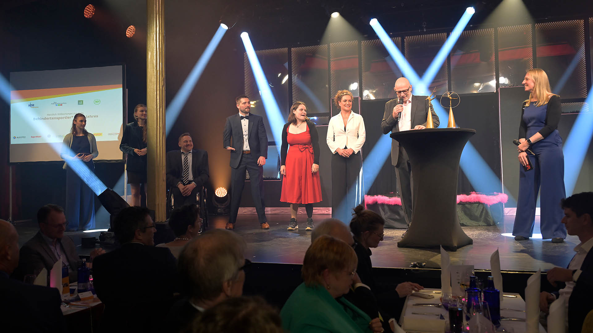 Vorstellung der nominierten Behindertensportler*innen 2025 auf der B hne zu Beginn der Gala. Von links: Laura Burbulla, Hermine Krumbein (leider zum Teil verdeckt von einer S ule), Jan Haller, marco Herbst, Flora Kliem, Isabell Nowak, Andreas Kuhnt und Nadine Matzat.