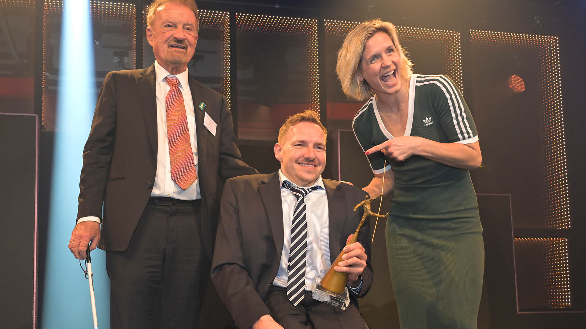Laura Ludwig freuts sich und zeigt auf den Behindertensportler des Jahres 2025, Jan Haller mit seinem Pokal. Von links: Karl Finke, Jan Haller, Laura Ludwig
